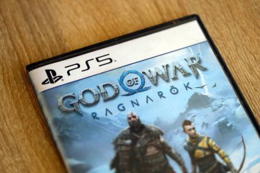 KYIV, UKRAINE - 8 EYLÜL 2025 Savaş Tanrısı Ragnarok video oyunu kahverengi ahşap masada yatıyor.