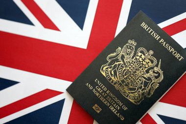 KYIV, UKRAINE - SEPTEMBER 17, 2025 Black British passport on UK Union Jack flag close up