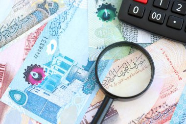 Bahreyn dinar para birimi faturaları ve yakınlaştırıcı bardaklı hesap makinesi. Vergilendirme ve para sayımı kavramı