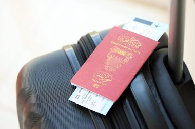 Seyahat çantasındaki Bahreyn pasaportu ve uçak biletleri yakın plan. Seyahat ve tatil kavramı