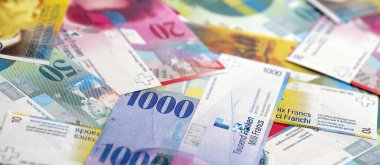 İsviçre frangı banknotları. Mevcut frank para faturaları büyük miktarda masada yatıyor. İsviçre 'de iş ve yatırım kavramı