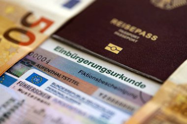 Alman pasaportu ve resmi vatandaşlık belgesinde bir kimlik kartı. Alman vatandaşlığının başarıyla kazanılması için sembolik yakın plan