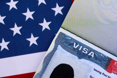 Birleşik Devletler bayrağı ve Birleşik Devletler vizesi. Göçmenlik ve Amerika Birleşik Devletleri 'ne seyahat kavramı. Amerikan bayrağının arka planındaki pasaportta vize var.