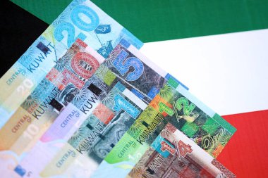 Kuveyt dinarı para birimi banknotları bayrağa yakın duruyor. İş ve yatırım kavramı