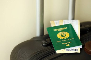 Nijerya pasaportu ve seyahat çantasındaki uçak biletleri yakın plan. Seyahat ve tatil kavramı