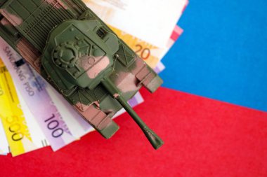 Filipinler 'in para birimi faturaları ve oyuncak tankları bayrakta. Ordu fonları ve silah satışları kavramı