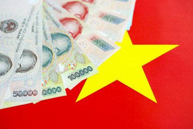 Vietnam dong para birimi banknotları bayrağa yakın duruyor. İş ve yatırım kavramı