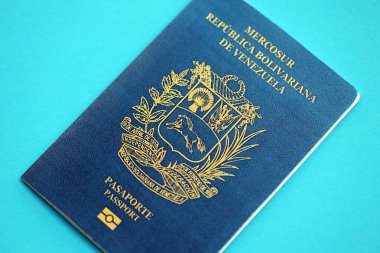 Venezuelan passport book on light blue paper background close up. Travel document on blue surface