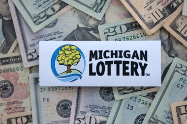 KYIV, UKRAINE - 22 Ekim 2025 Michigan Piyango Şirketi logosu birçok dolarlık banknotları kapatın