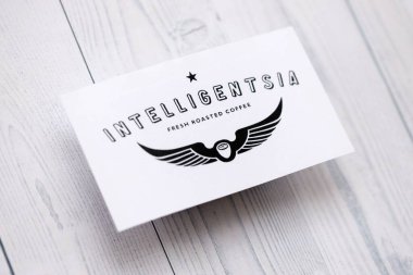 KYIV, UKRAINE - 5 Ekim 2025 Intelligentsia kahve markası logosu beyaz ahşap masa üzerinde yakın plan