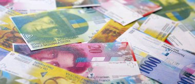 İsviçre frangı banknotları. Mevcut frank para faturaları büyük miktarda masada yatıyor. İsviçre 'de iş ve yatırım kavramı
