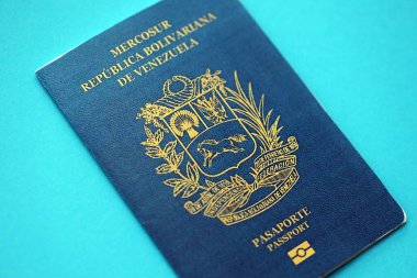Venezuelan passport book on light blue paper background close up. Travel document on blue surface