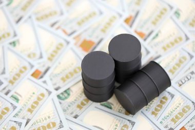 Barrels of oil on bills of American dollars. purchase, sale of oil concept close up