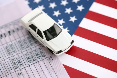 Oyuncak araba ehliyeti Birleşik Devletler bayrağına yakın. Ehliyet numune kartı ve Amerikan bayrağı