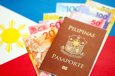Filipinler pezosu para ve pasaport banknotları bayrağın üzerinde. Seyahat ve tatil kavramı