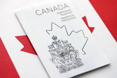 Canadian temporary passport lies on canadian flag close up