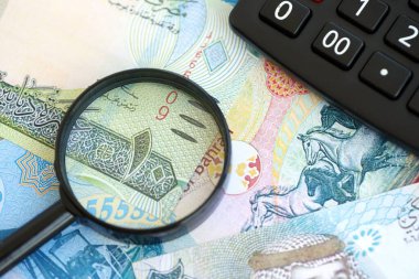 Bahreyn dinar para birimi faturaları ve yakınlaştırıcı bardaklı hesap makinesi. Vergilendirme ve para sayımı kavramı