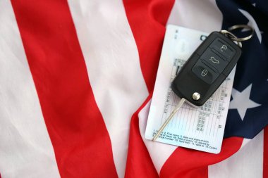 Uzaktan kumandalı ateşleme anahtarları ve ABD bayrağında ehliyet kartı. Amerika 'da araba kullanma kavramı. Araç sahipliği