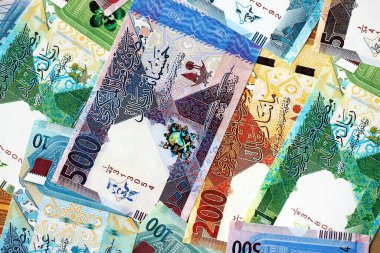 Katarlı riyal para banknotları masanın üzerinde büyük bir yığın halinde duruyor. Katar 'da finans ve iş kavramı