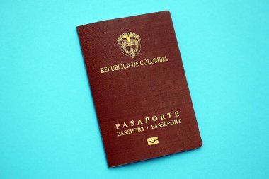 Açık mavi masa üzerinde Kolombiya Cumhuriyeti kırmızı pasaportu yakın plan. Seyahat ve turizm kavramı