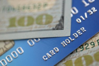 Bankacılık ve ödemeler için mavi kredi kartına 100 dolar banknot. İş ve banka hizmeti kavramı