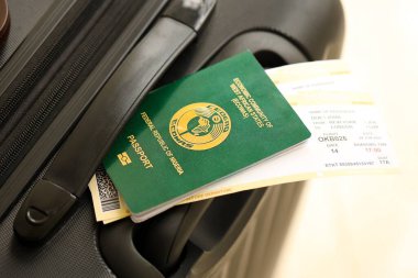 Nijerya pasaportu ve seyahat çantasındaki uçak biletleri yakın plan. Seyahat ve tatil kavramı