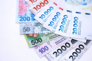 Arjantin pezosu büyük miktarlarda para beyaz masada yakın planda yatıyor. Finans ve bankacılık kavramı