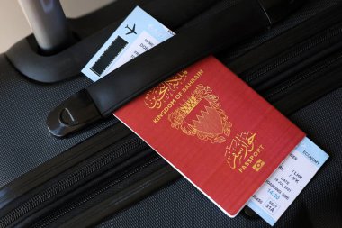 Seyahat çantasındaki Bahreyn pasaportu ve uçak biletleri yakın plan. Seyahat ve tatil kavramı