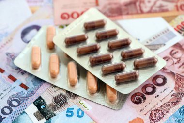 Tayland baht para birimi faturaları ve ilaç hapları. İlaç ve eczane kavramı