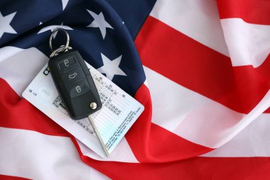 Uzaktan kumandalı ateşleme anahtarları ve ABD bayrağında ehliyet kartı. Amerika 'da araba kullanma kavramı. Araç sahipliği