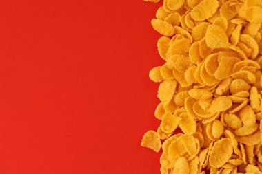 Kahvaltı gevreklerinin arka planında büyük miktarda kırmızı arka planda yakın plan, üst manzara.