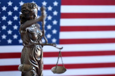 Hukuk ve adalet Amerika Birleşik Devletleri'ndeki bürolarından denetlenmekte, heykel Bayan Adalet ABD bayrağı arka planda, seçici odak ile