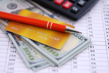 Kredi kartı ve tükenmez kalemle Amerikan Doları 'na ait para banknotları hesaplama belgelerinde. Amerika Birleşik Devletleri 'nde iş, mali işlemler ve muhasebe