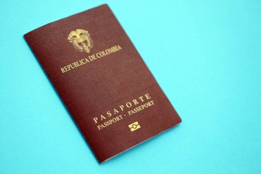Açık mavi masa üzerinde Kolombiya Cumhuriyeti kırmızı pasaportu yakın plan. Seyahat ve turizm kavramı
