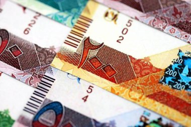 Katarlı riyal para banknotları masanın üzerinde büyük bir yığın halinde duruyor. Katar 'da finans ve iş kavramı
