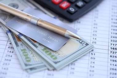 Kredi kartı ve tükenmez kalemle Amerikan Doları 'na ait para banknotları hesaplama belgelerinde. Amerika Birleşik Devletleri 'nde iş, mali işlemler ve muhasebe