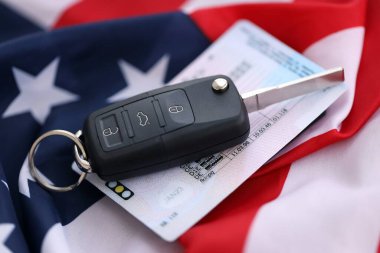 Uzaktan kumandalı ateşleme anahtarları ve ABD bayrağında ehliyet kartı. Amerika 'da araba kullanma kavramı. Araç sahipliği