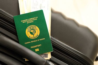 Nijerya pasaportu ve seyahat çantasındaki uçak biletleri yakın plan. Seyahat ve tatil kavramı