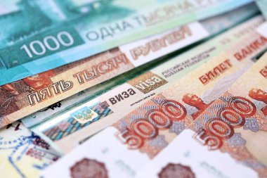 Fragment of Russian Federation visa in passport page and russian rubles money bills close up. Concept of travel and tourism worldwide