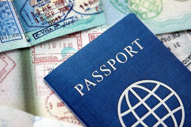 Birçok açık pasaport sayfası, bir sürü vize ve çeşitli ülkelerden pasaport kontrolünden giriş damgalarıyla dolu. Dünya çapında seyahat ve turizm kavramı