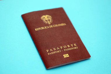 Açık mavi masa üzerinde Kolombiya Cumhuriyeti kırmızı pasaportu yakın plan. Seyahat ve turizm kavramı