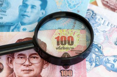 Tayland baht para birimi faturaları ve büyüteç yakın çekim. Finansal izleme ve vergilendirme kavramı