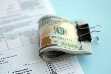 Masada 1040 bireysel gelir vergisi iadesi formuyla birlikte büyük miktarda Amerikan dolarları var. ABD 'de vergilendirme ve muhasebe kavramı