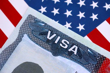 Birleşik Devletler bayrağı ve Birleşik Devletler vizesi. Göçmenlik ve Amerika Birleşik Devletleri 'ne seyahat kavramı. Amerikan bayrağının arka planındaki pasaportta vize var.