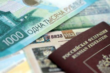 Pasaport sayfasında Rusya Federasyonu vizesinin bir parçası ve Rus parası yakın planda. Rusya 'da seyahat ve turizm kavramı