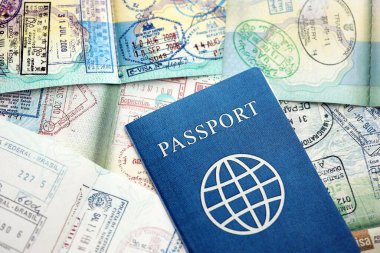 Birçok açık pasaport sayfası, bir sürü vize ve çeşitli ülkelerden pasaport kontrolünden giriş damgalarıyla dolu. Dünya çapında seyahat ve turizm kavramı