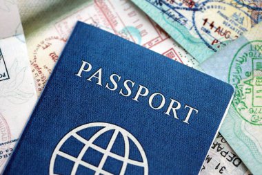 Birçok açık pasaport sayfası, bir sürü vize ve çeşitli ülkelerden pasaport kontrolünden giriş damgalarıyla dolu. Dünya çapında seyahat ve turizm kavramı