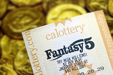 KYIV, UKRAINE - 22 Ekim 2025 Fantezi 5 piyango bileti altın paraların üzerinde yatıyor