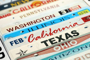 Çeşitli eyalet isimleriyle eski bir Amerikan araba plakası. Amerika 'da araba kullanma kavramı. Araç ruhsatına ulaşılıyor.