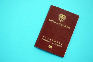 Açık mavi masa üzerinde Kolombiya Cumhuriyeti kırmızı pasaportu yakın plan. Seyahat ve turizm kavramı